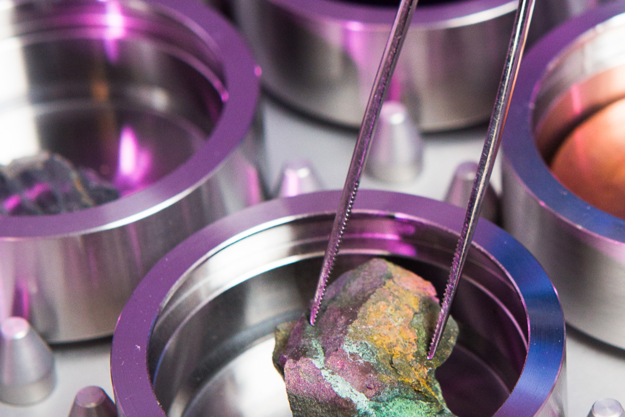 Tweezers picking up colourful rocks